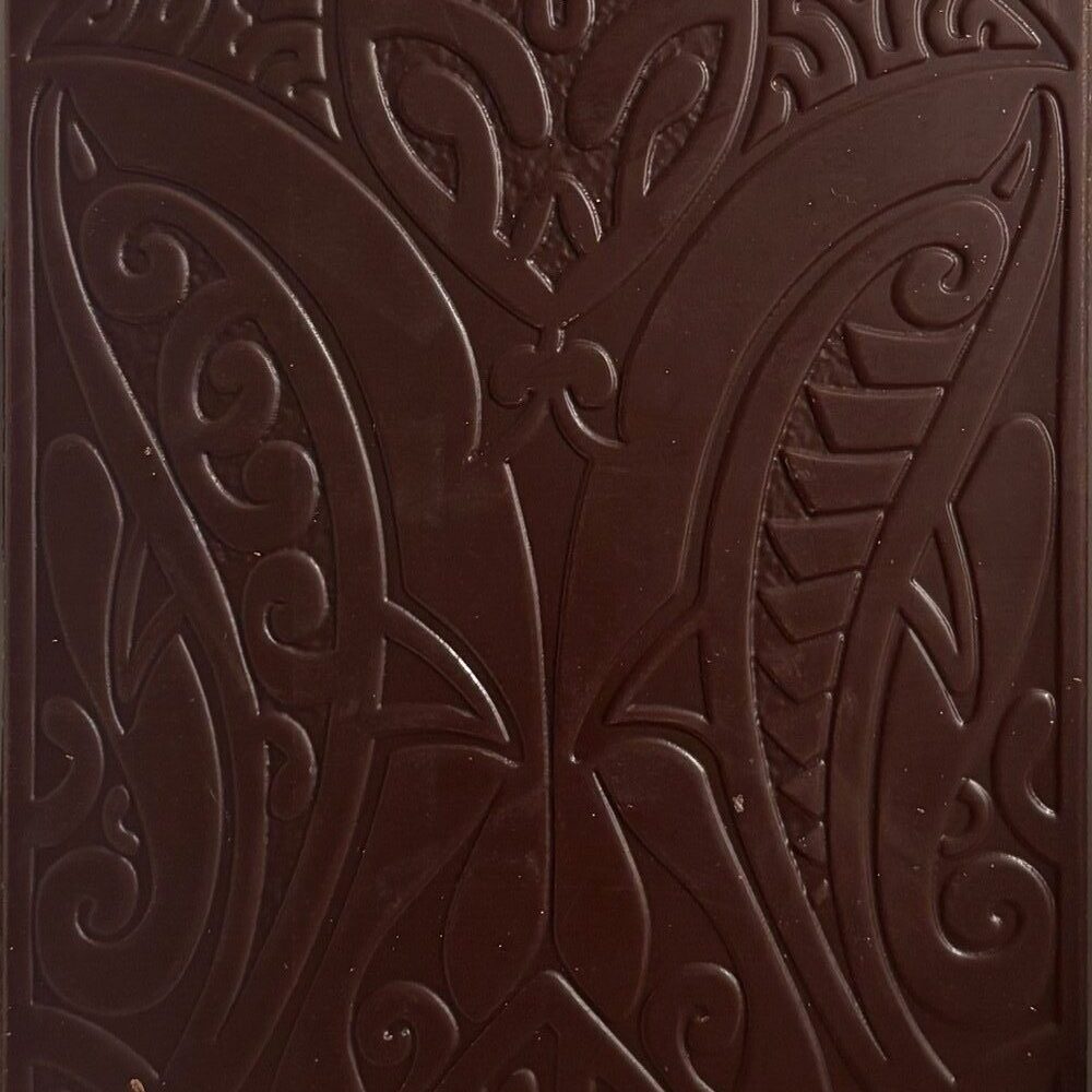 Unwrapped Tahiti dark chocolate bar with intricate floral patterns carved into bar